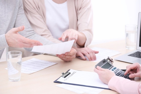 people with paperwork and calculator