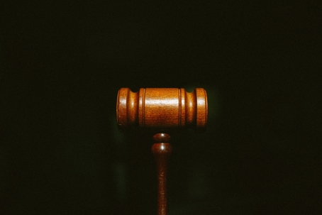 A half of a gavel, placed in front of a black background.